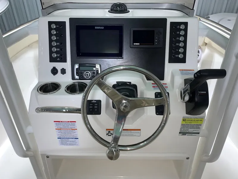 Slide: The Image of 2024 Robalo R222 Explorer boat dashboard with steering wheel and navigation controls. - 7