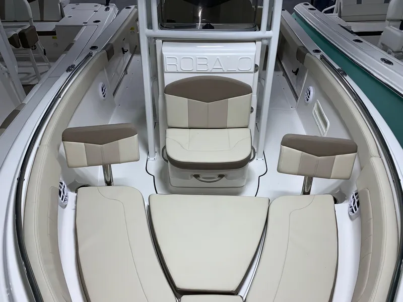 Slide: The Image of 2024 Robalo R222 Explorer boat interior with beige and brown seating. - 13