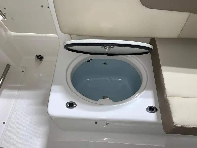Slide: The Image of 2024 Robalo R222 Explorer boat livewell with open lid and seating area. - 6