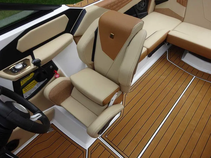 Slide: The Image of 2023 Nautique S21 boat interior with tan and brown seating and teak flooring. - 10