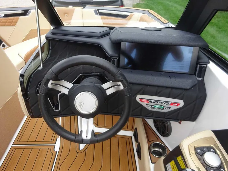Slide: The Image of 2023 Nautique S21 boat dashboard with steering wheel and touchscreen display. - 11