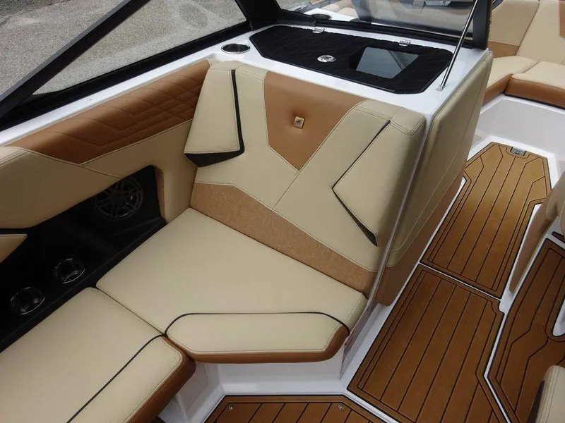 Slide: The Image of 2023 Nautique S21 boat interior with tan and brown seating and teak flooring. - 13