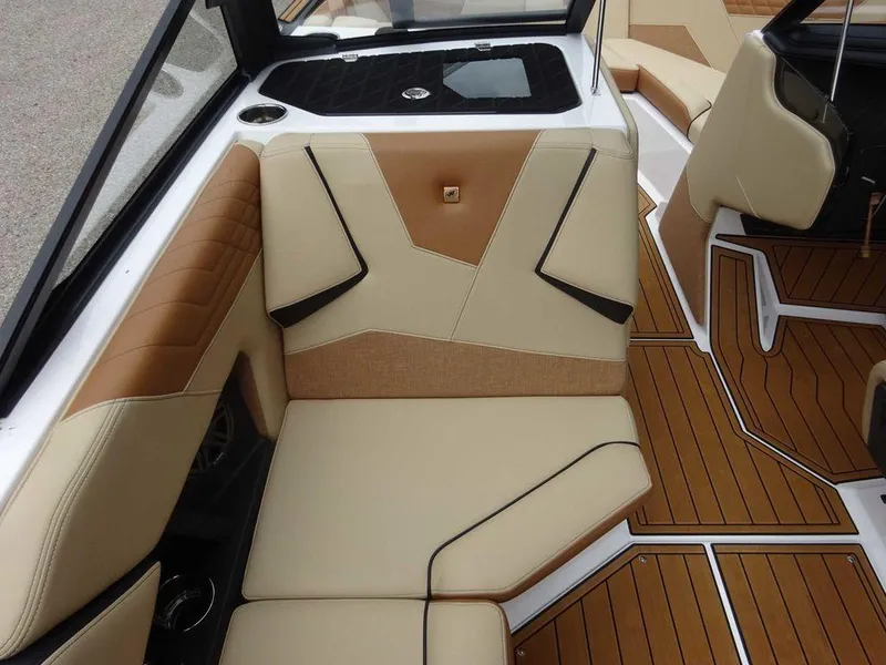 Slide: The Image of 2023 Nautique S21 interior with tan and brown seating, teak flooring, and modern design. - 14