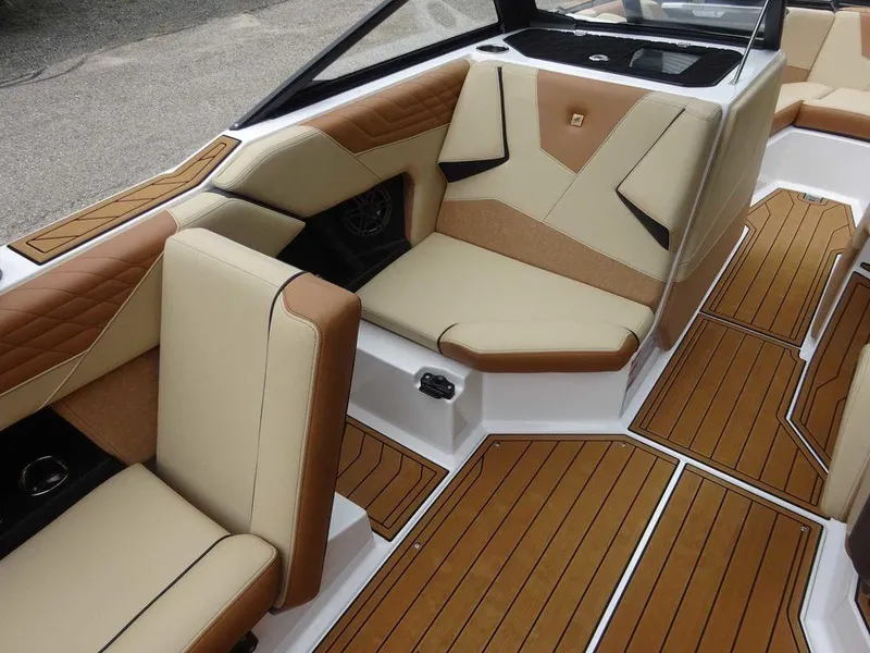 Slide: The Image of 2023 Nautique S21 boat interior with tan and brown seating, teak flooring. - 15