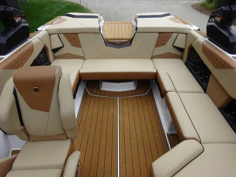 Slide: The Image of 2023 Nautique S21 boat interior with luxurious tan and brown seating. - 16