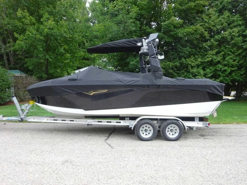 Slide: The Image of 2023 Nautique S21 boat on trailer with black cover. - 3