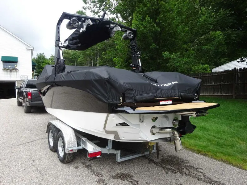 Slide: The Image of 2023 Nautique S21 boat on trailer with cover, parked in driveway. - 4