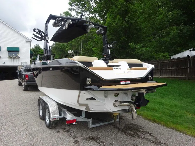 Slide: The Image of 2023 Nautique S21 boat on trailer, black and white exterior, parked outdoors. - 6