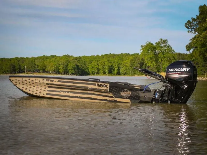 Slide: The Image of 2022 Havoc 1860 Dbst boat with American flag design on a calm lake. - 11