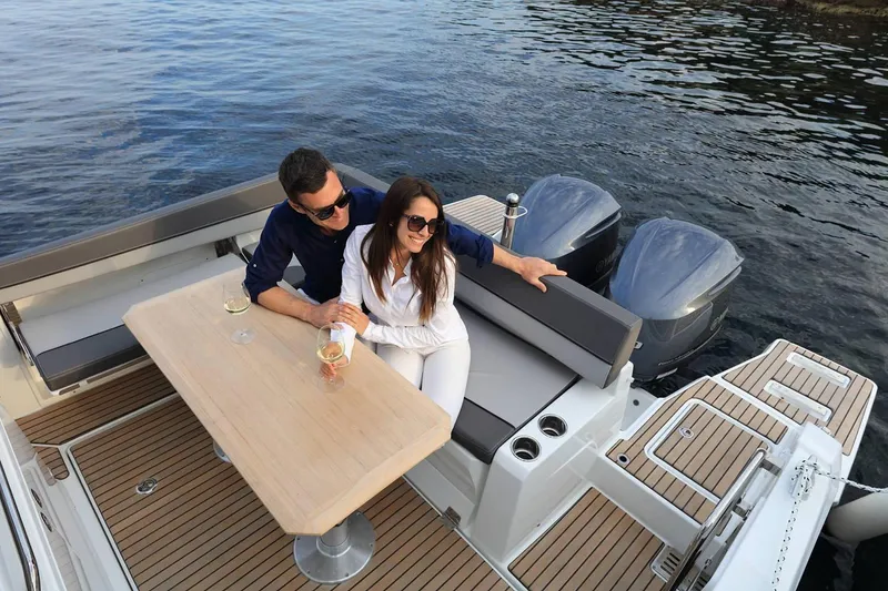Slide: The Image of 2024 Jeanneau Leader 9.0 CC boat with spacious seating at the bow, docked by the water. - 11