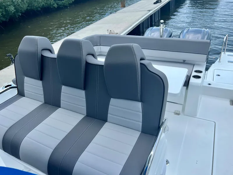 Slide: The Image of 2024 Jeanneau Leader 9.0 CC boat interior with gray and white seating. - 15