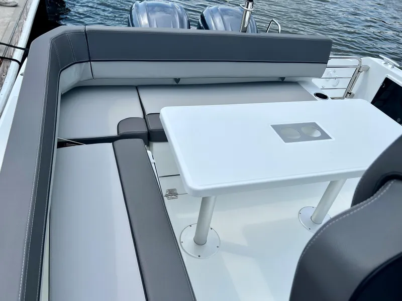 Slide: The Image of 2024 Jeanneau Leader 9.0 CC boat with cushioned seating and table. - 17