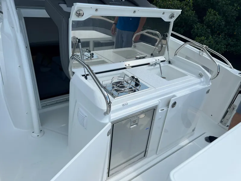 Slide: The Image of 2024 Jeanneau Leader 9.0 CC boat kitchen area with stove, sink, and storage. - 22
