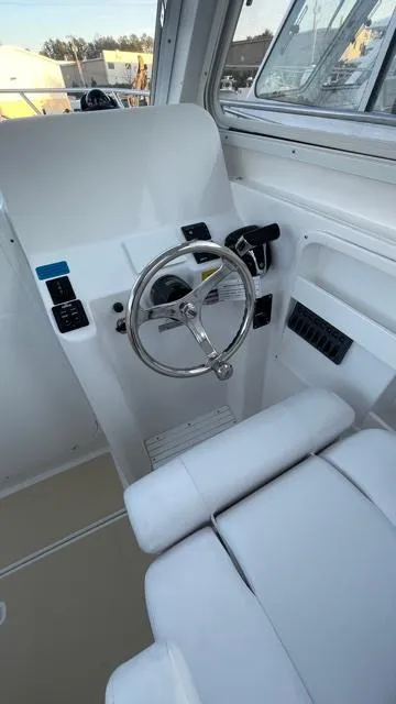 Slide: The Image of 2022 NorthCoast 235 HT boat helm with steering wheel and controls. - 12