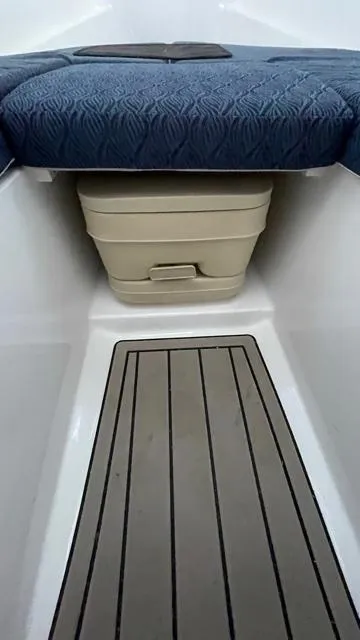 Slide: The Image of 2022 NorthCoast 235 HT interior with cushioned seating and storage compartment. - 13