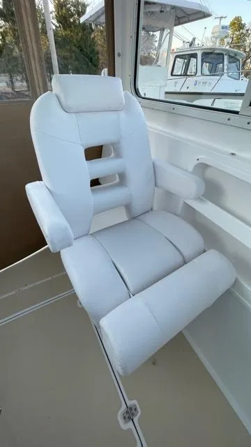 Slide: The Image of White captain's chair in 2022 NorthCoast 235 HT boat interior. - 15