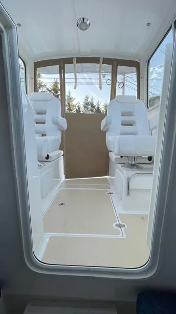 Slide: The Image of Interior of 2022 NorthCoast 235 HT boat with white seating and modern design. - 16