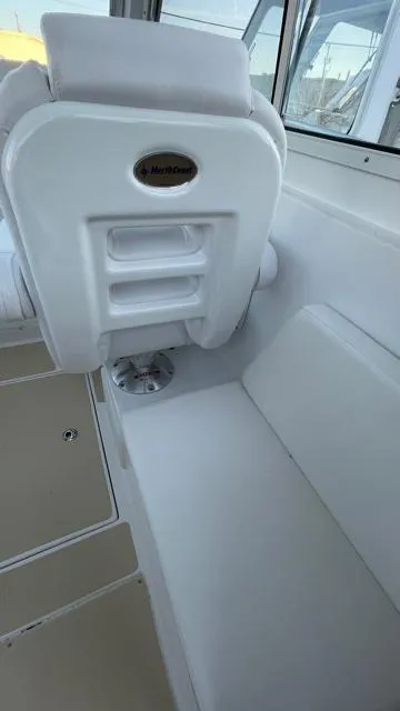 Slide: The Image of Interior of a 2022 NorthCoast 235 HT boat, featuring white seating and storage compartments. - 17
