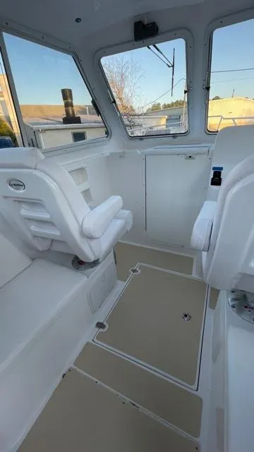 Slide: The Image of Interior of 2022 NorthCoast 235 HT boat, featuring seating and windows. - 19