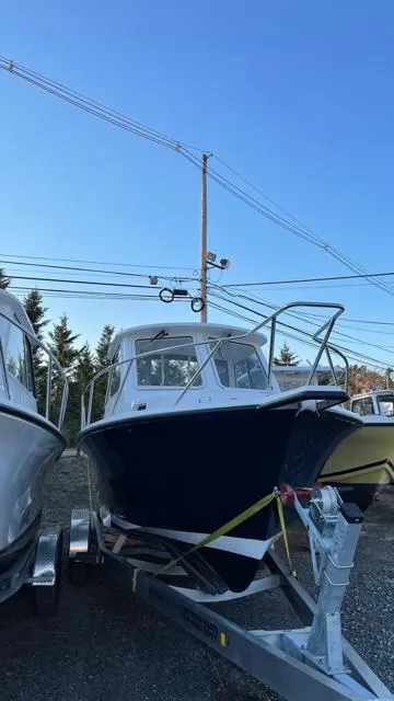 Slide: The Image of 2022 NorthCoast 235 HT boat on trailer, parked outdoors under clear sky. - 22