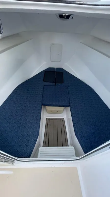 Slide: The Image of 2022 NorthCoast 235 HT boat interior with blue cushions and wooden flooring. - 23