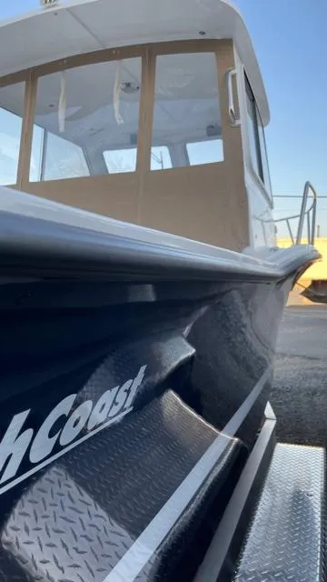 Slide: The Image of 2022 NorthCoast 235 HT boat, side view, showcasing sleek design and cabin details. - 3