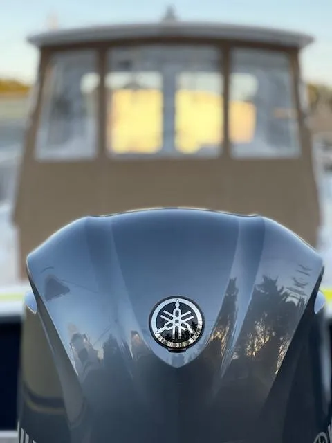 Slide: The Image of 2022 NorthCoast 235 HT boat with Yamaha engine, blurred cabin background. - 6