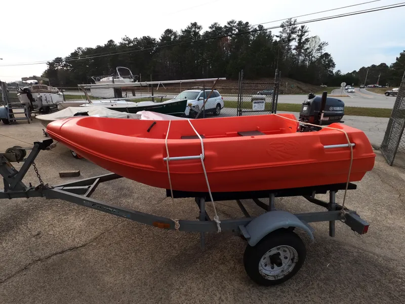 Slide: The Image of Red River Boats 290 on trailer, 2022 model, parked outdoors. - 2