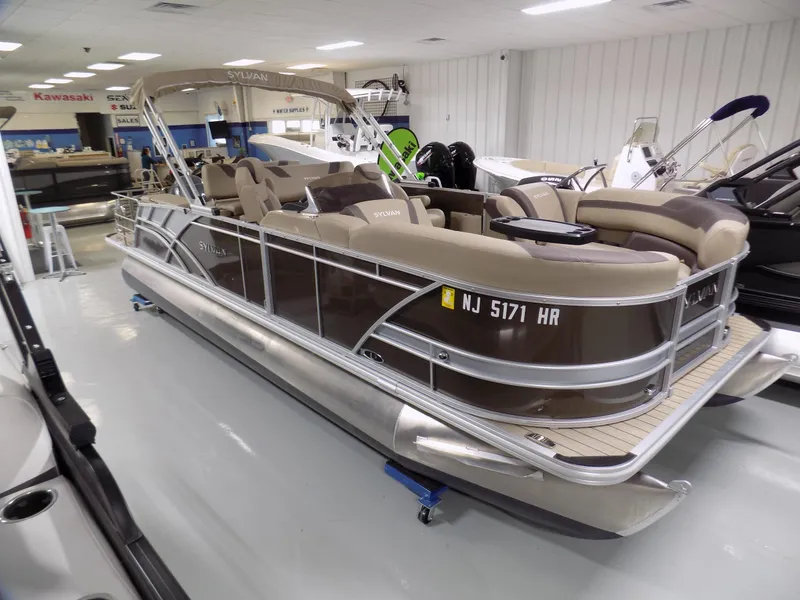 Slide: The Image of 2022 Sylvan L3 DLZ pontoon boat displayed in a showroom. - 0