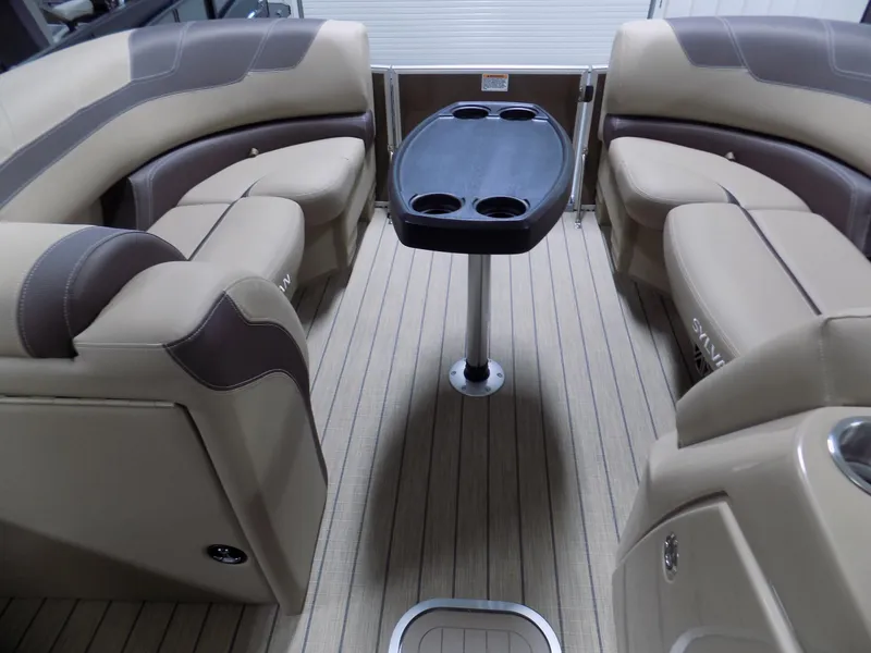 Slide: The Image of Luxurious interior of 2022 Sylvan L3 DLZ pontoon boat with beige seating and central table. - 2