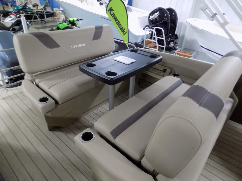 Slide: The Image of 2022 Sylvan L3 DLZ boat interior with beige seating and table, displayed in showroom. - 4