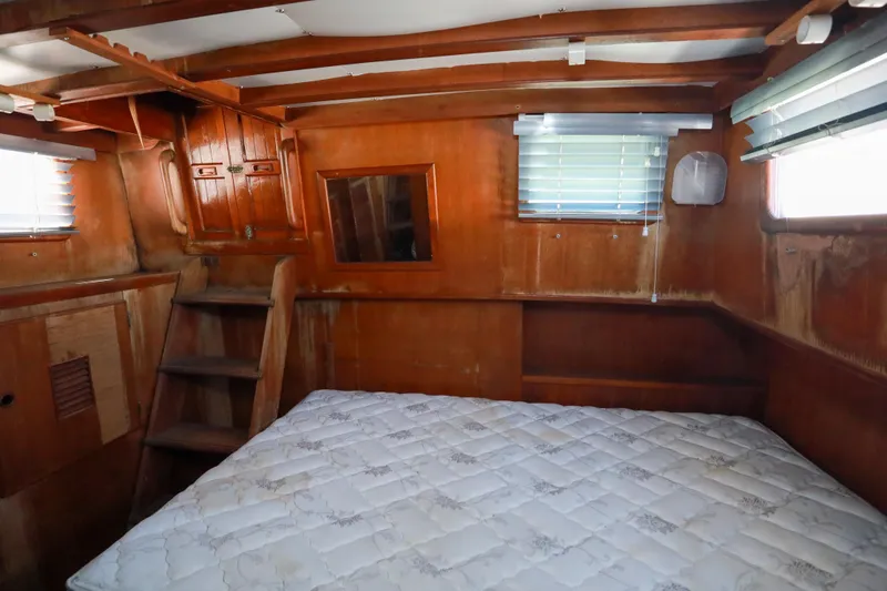 Slide: The Image of 1979 Sea Ranger 37 cabin interior with wooden walls, mattress, and small windows. - 23