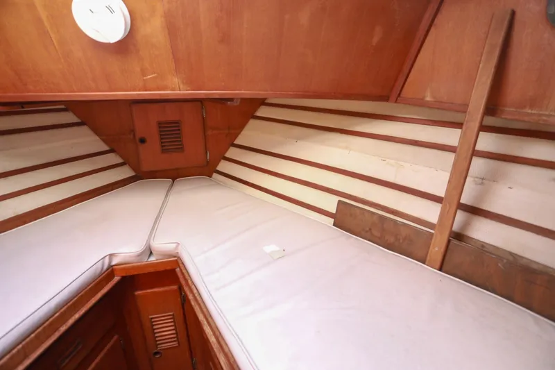 Slide: The Image of 1979 Sea Ranger 37 interior cabin with wooden paneling and cushioned sleeping area. - 27
