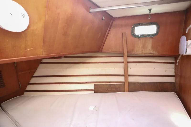 Slide: The Image of 1979 Sea Ranger 37 cabin interior with wooden paneling and a small window. - 28