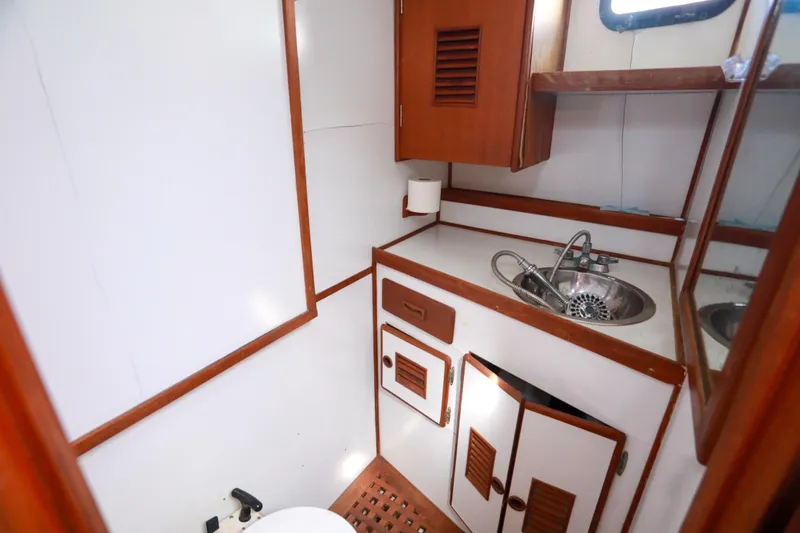 Slide: The Image of 1979 Sea Ranger 37 yacht bathroom with wooden cabinetry and stainless steel sink. - 30
