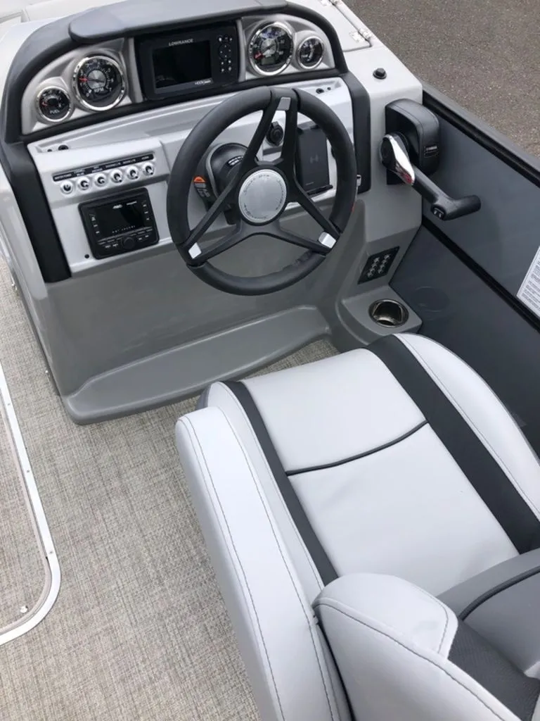 Slide: The Image of 2023 South Bay S224CR2 2.75 boat cockpit with steering wheel and control panel. - 11
