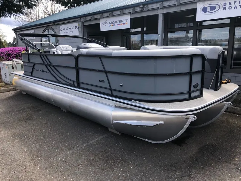 Slide: The Image of 2023 South Bay S224CR2 2.75 pontoon boat displayed at a dealership. - 2