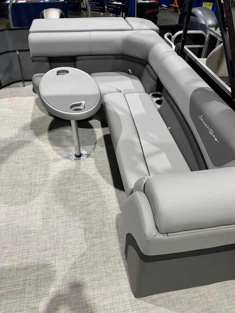 Slide: The Image of 2023 South Bay S224CR2 2.75 pontoon boat interior with gray seating and table. - 3