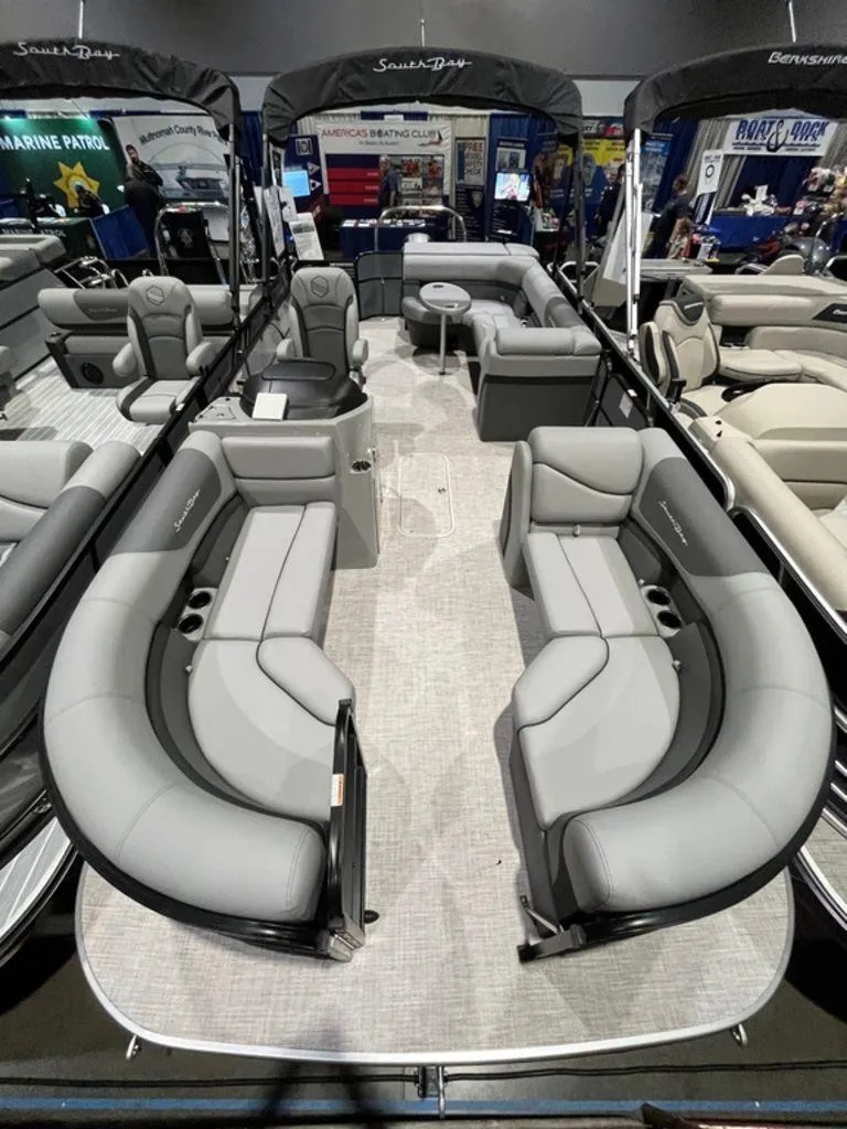Slide: The Image of 2023 South Bay S224CR2 2.75 pontoon boat with spacious seating at a boat show. - 5