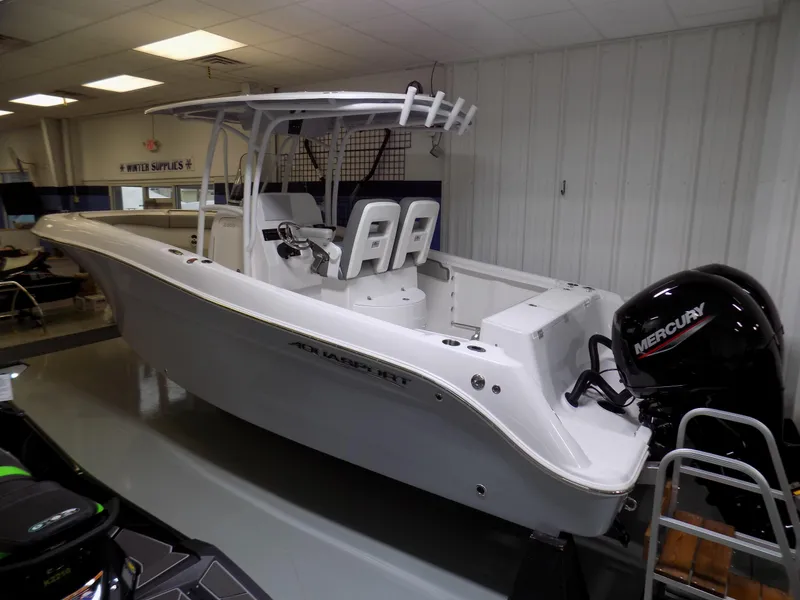 Slide: The Image of 2022 Aquasport 2500 boat with Mercury engine in showroom setting. - 2