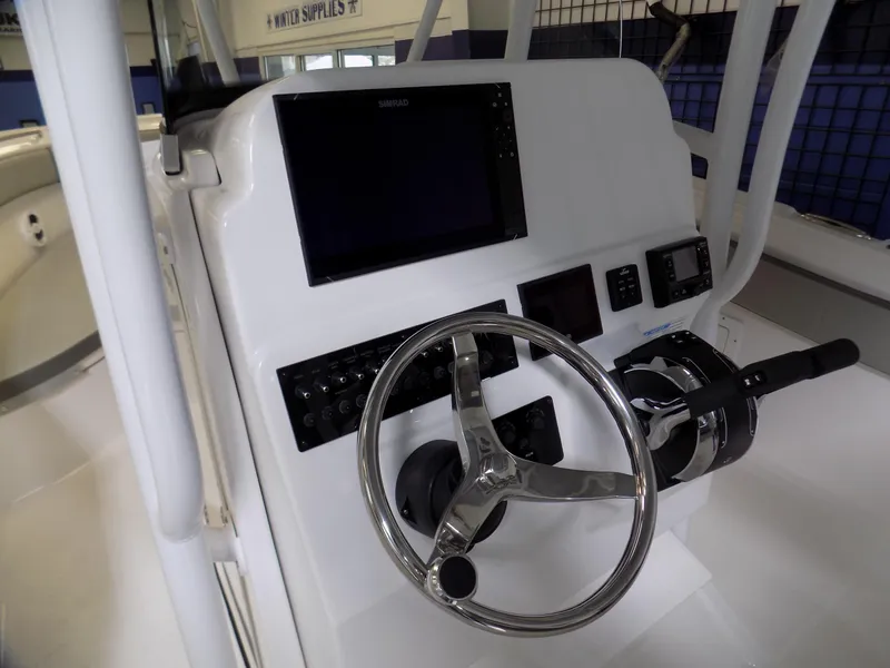 Slide: The Image of 2022 Aquasport 2500 boat dashboard with steering wheel and electronic controls. - 7