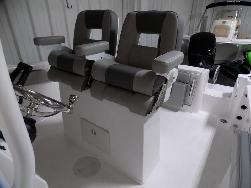 Slide: The Image of 2022 Aquasport 2500 boat interior with dual gray captain seats and steering wheel. - 8