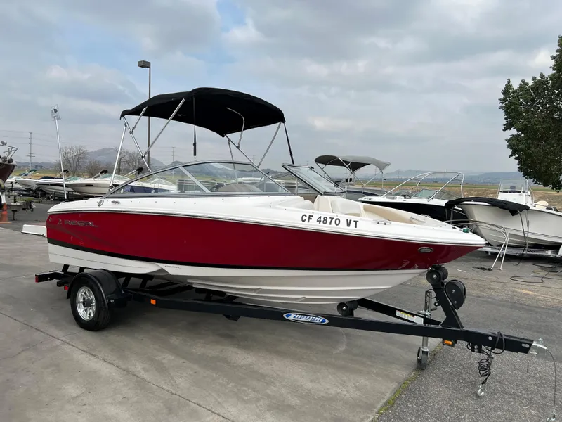 The Image of 2013 Regal 1900 boat with red and white exterior on a trailer. - 1