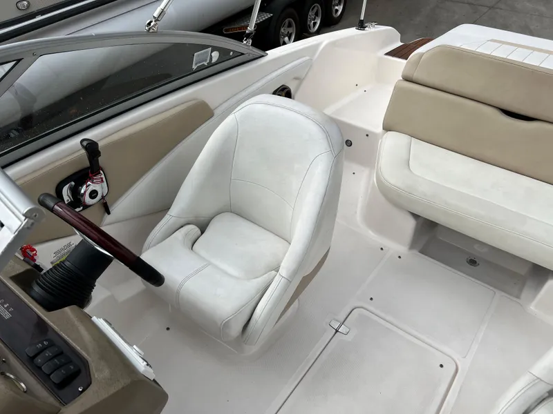 Slide: The Image of 2013 Regal 1900 boat interior with white captain's chair and beige seating. - 12