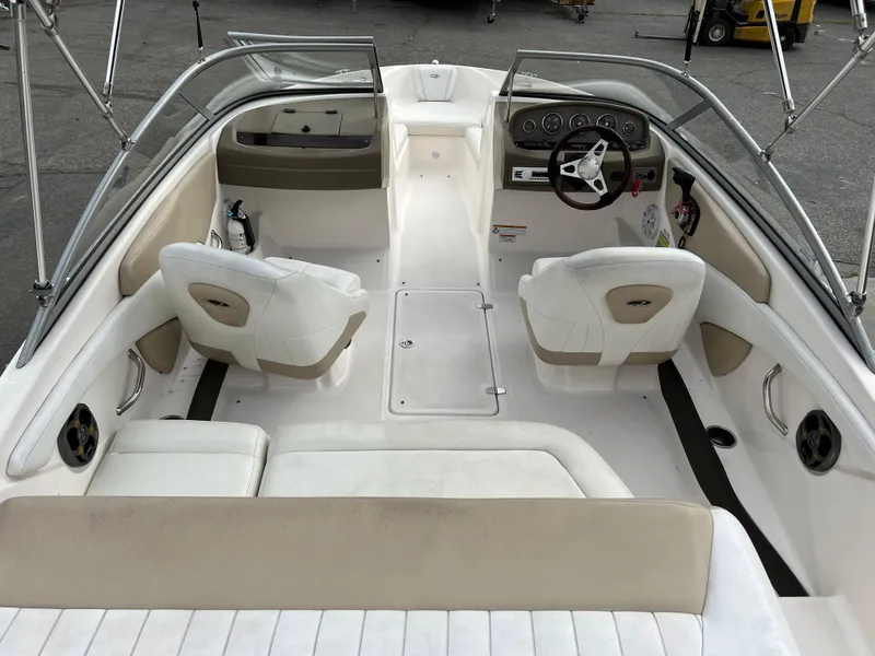 Slide: The Image of 2013 Regal 1900 boat interior with white and beige seating, steering console, and windshield. - 8