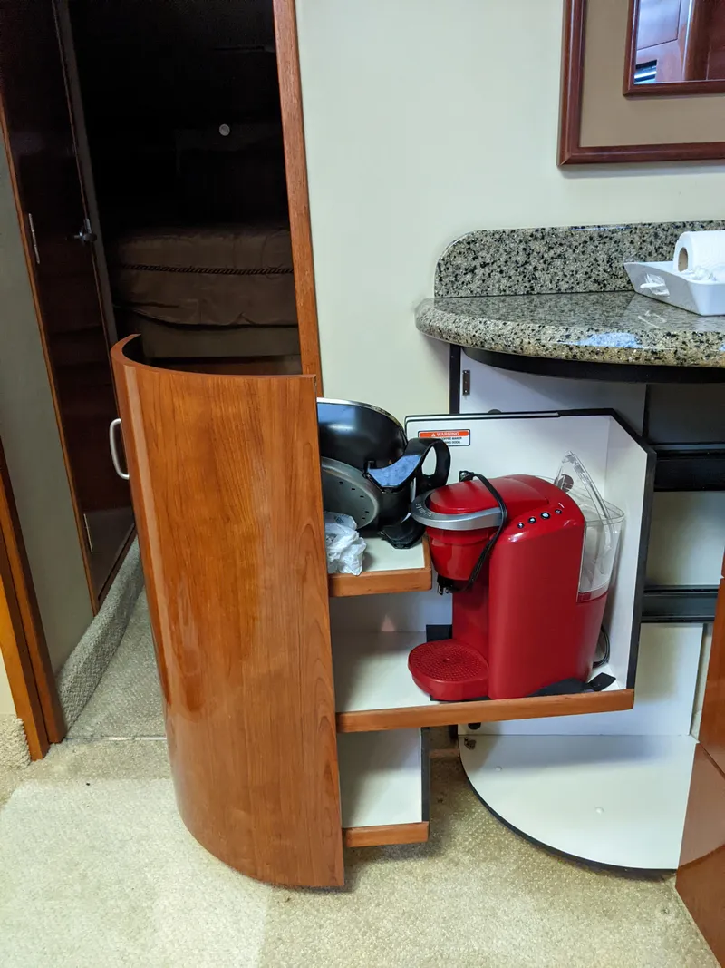 Slide: The Image of Wooden cabinet with a coffee maker and kitchenware inside a 2006 Sea Ray 44 Sundancer yacht. - 22
