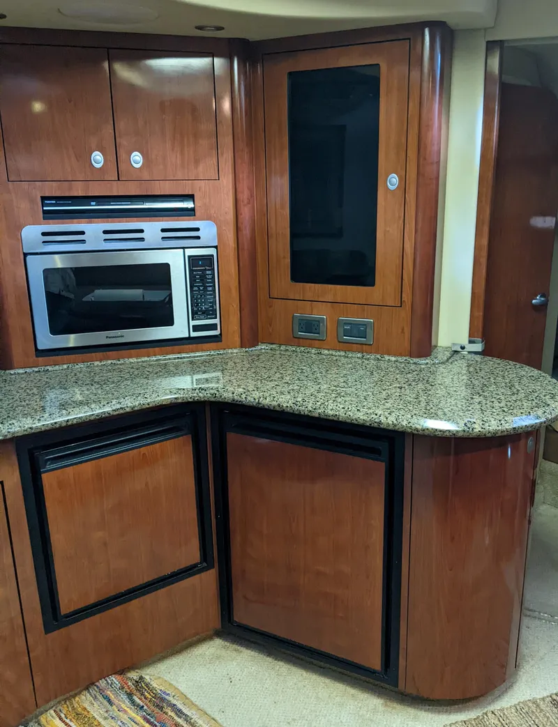 Slide: The Image of 2006 Sea Ray 44 Sundancer kitchen with granite countertops and modern appliances. - 23