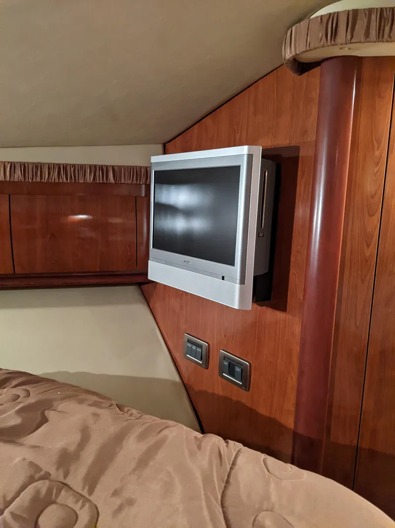 Slide: The Image of 2006 Sea Ray 44 Sundancer cabin with mounted TV and wood paneling. - 26