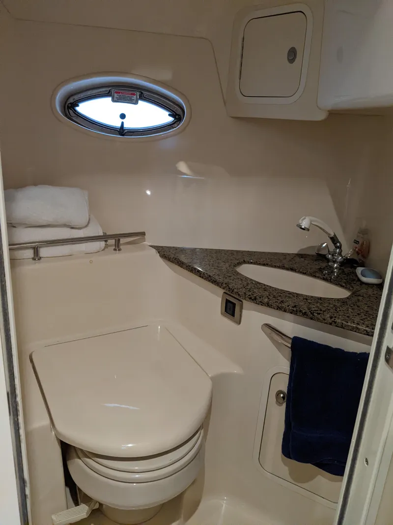Slide: The Image of 2006 Sea Ray 44 Sundancer bathroom with granite countertop and porthole window. - 31