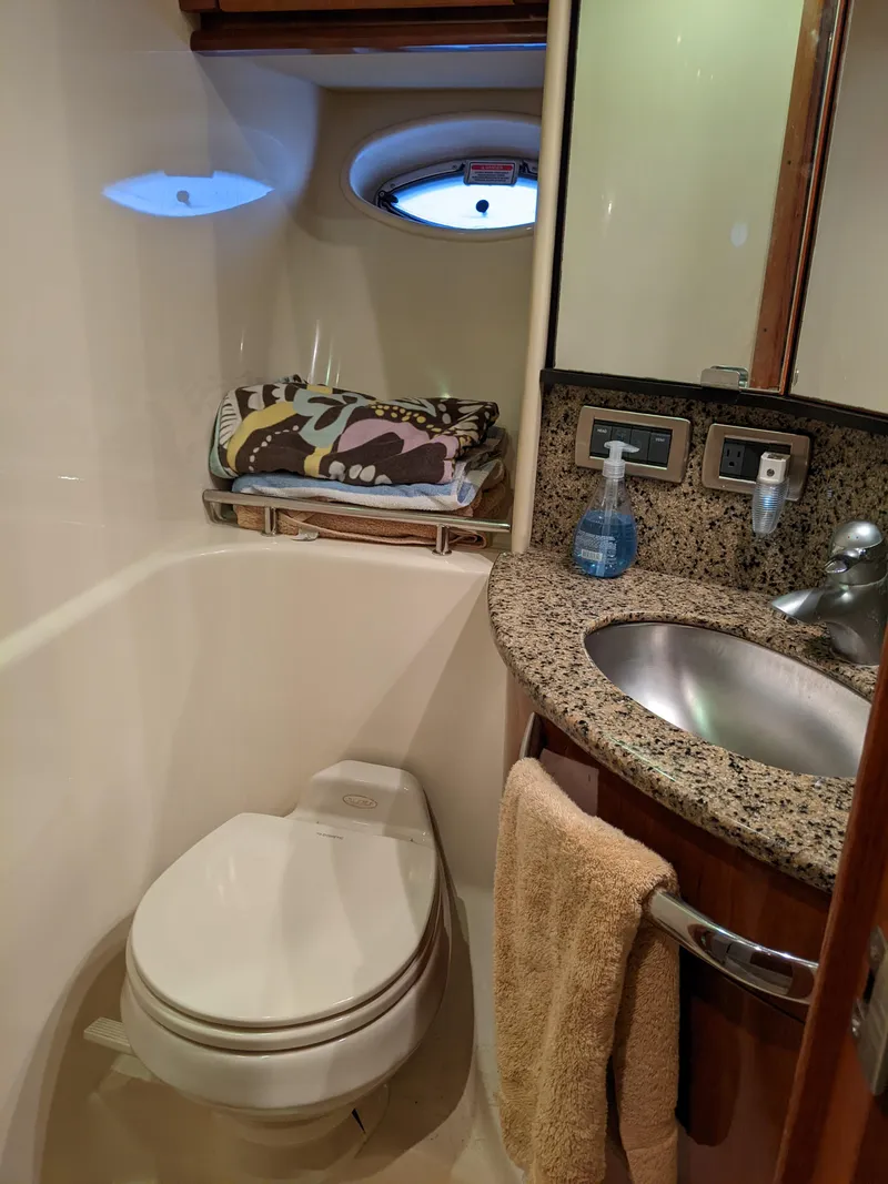 Slide: The Image of 2006 Sea Ray 44 Sundancer yacht bathroom with toilet, sink, and porthole window. - 32